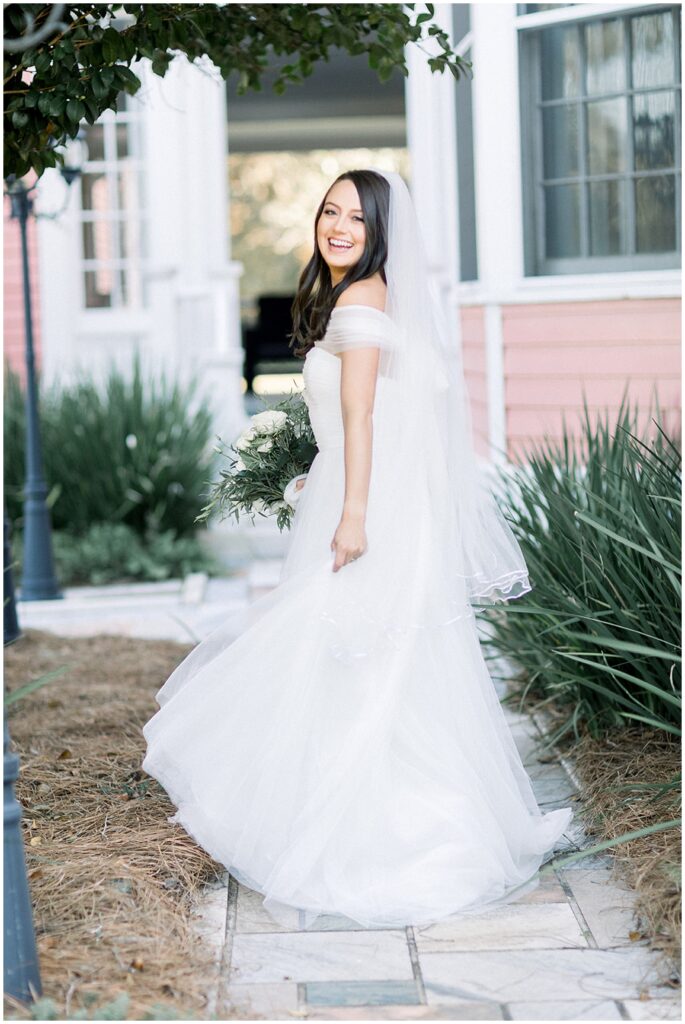 A bride walks down a stone path in a garden at south eden plantation