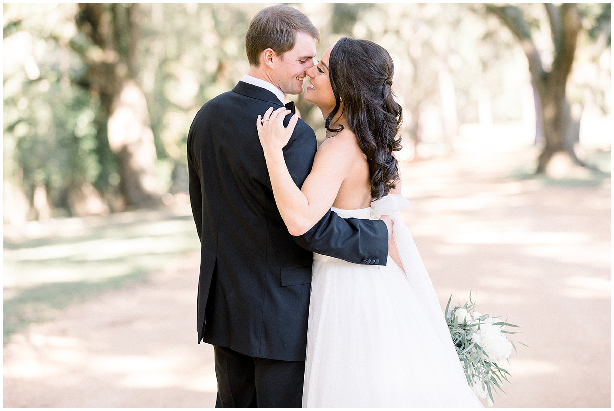 Newlyweds kiss on an unpaved road surrounded by old oak trees at south eden plantation