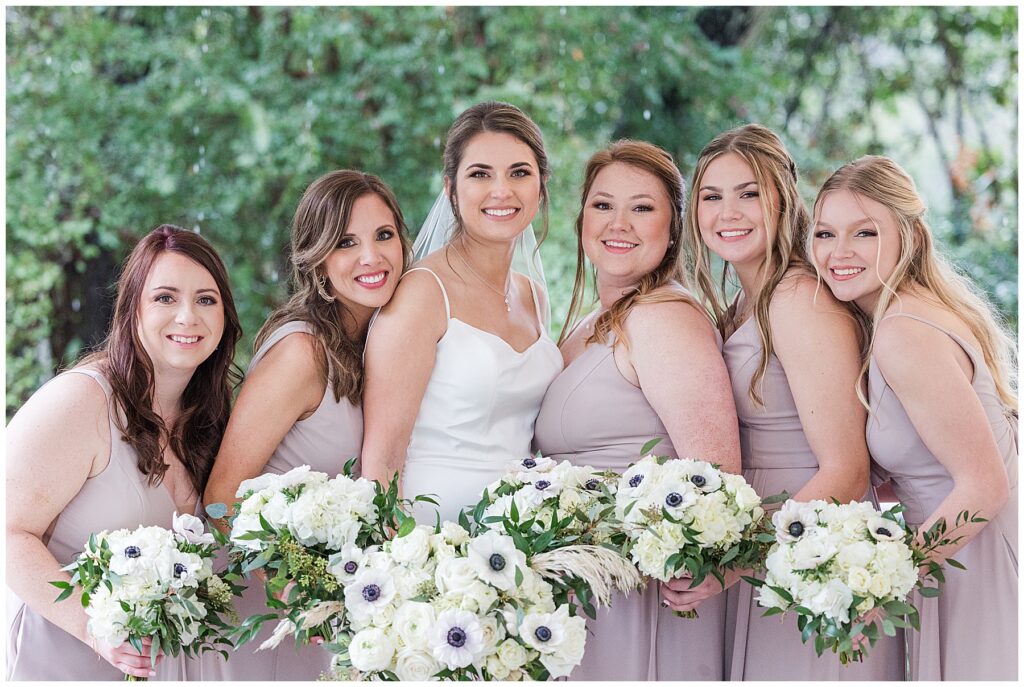 Bride laughing with bridesmaids in matching robes before ceremony at Shiloh Farm in Tallahassee