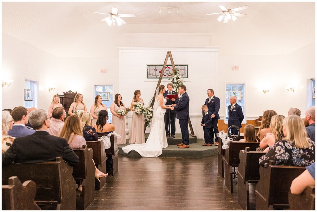 Wedding ceremony setup at Shiloh Farm with wooden arch, greenery, and guests seated outdoors in Tallahassee