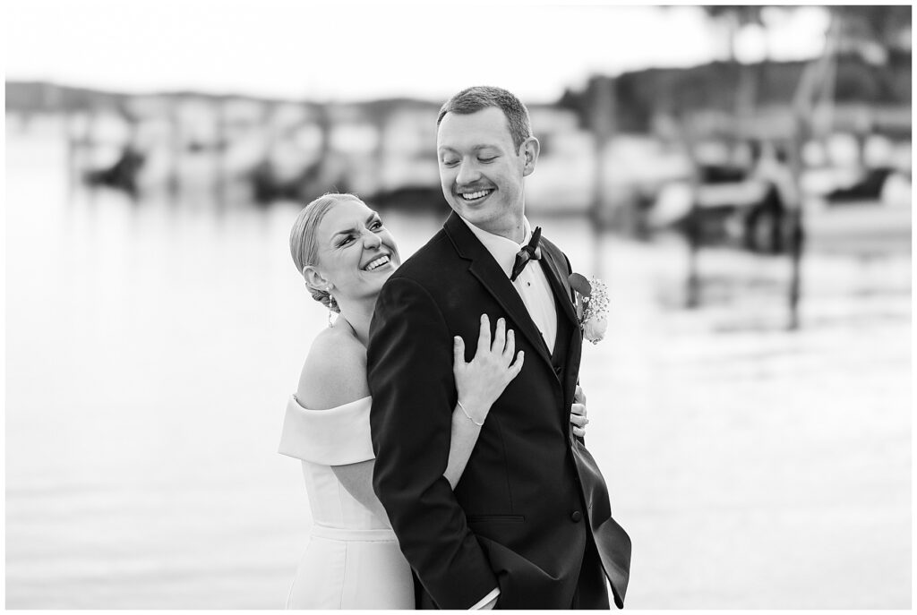 Bride and groom sharing a kiss at golden hour on the waterfront during their Florida wedding.