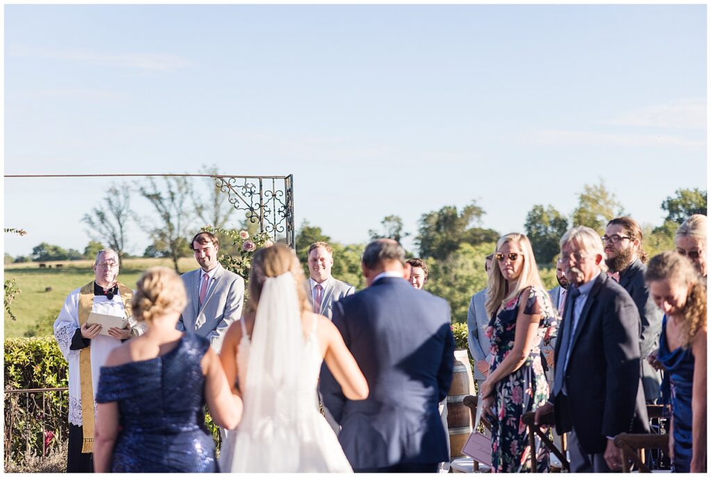 groom watching bride walk down aisle