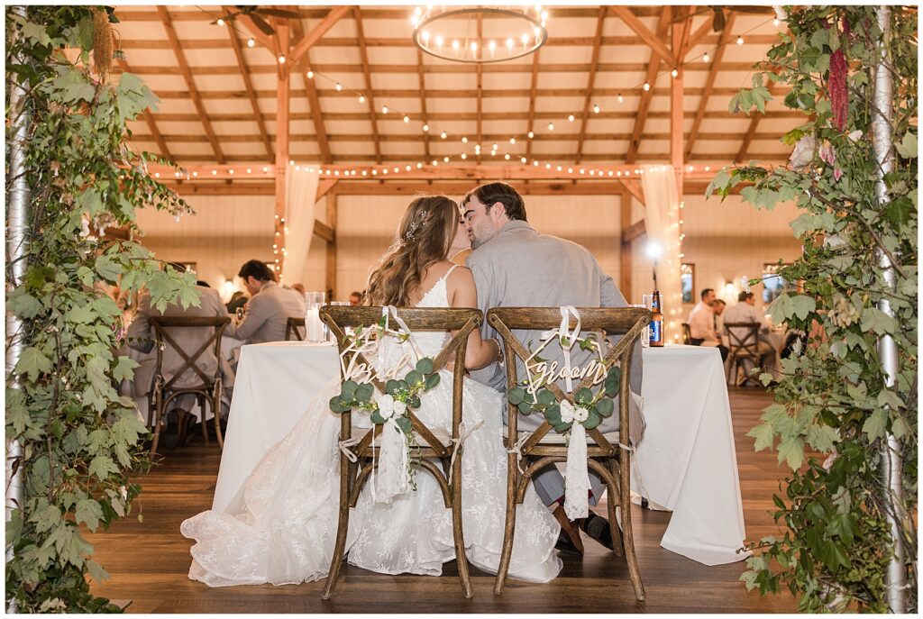 bride and groom share a kiss during their wedding reception 