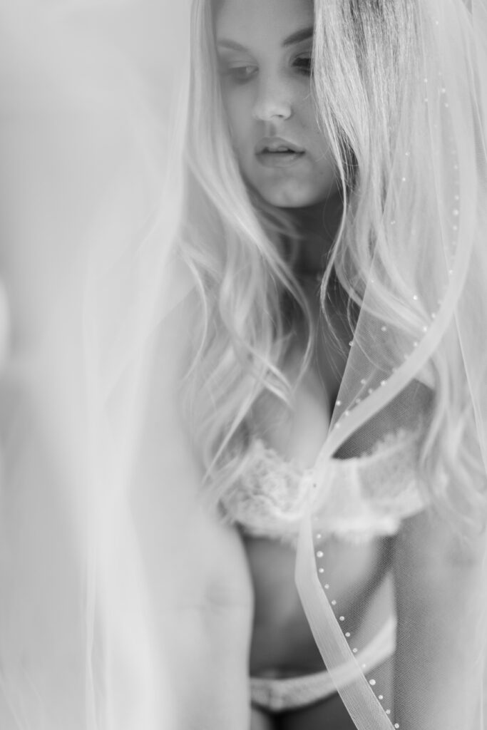bride in white lingerie and wearing her veil for boudoir photos
