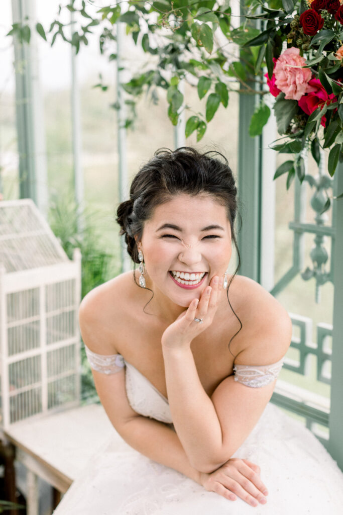 Bride posing in her wedding dress for her bridal portraits next to her flowers