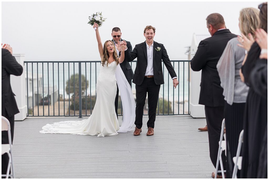 Couple recessed down the rooftop aisle with the coastal fog behind them.