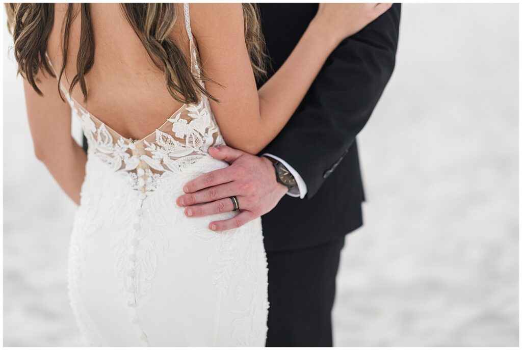 Groom embracing bride and showing off his new ring