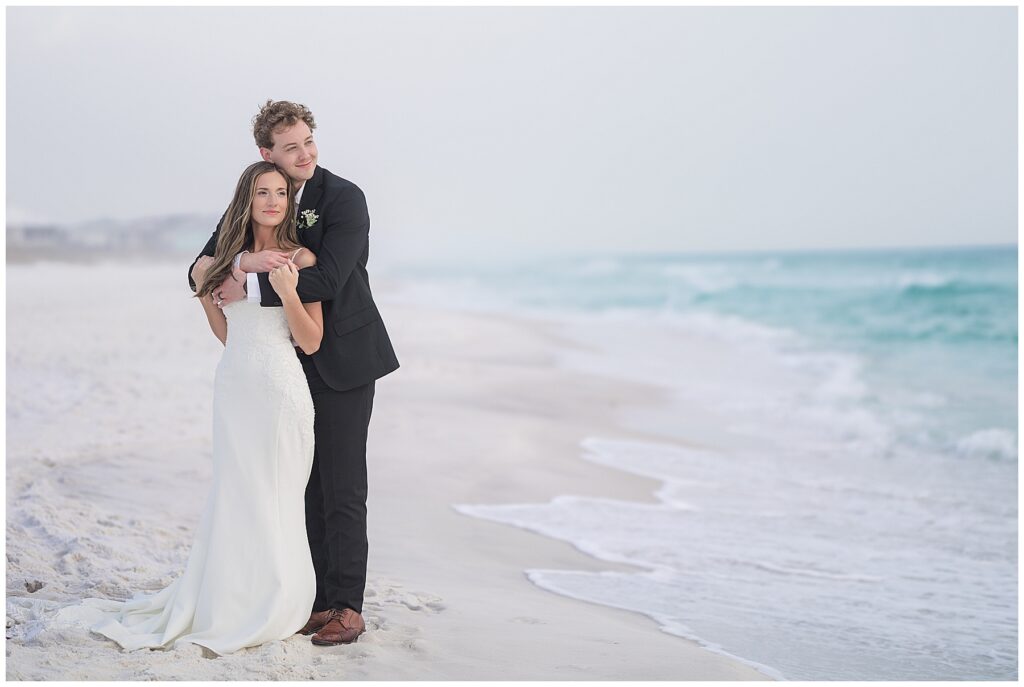 Bride and groom watching the ocean 