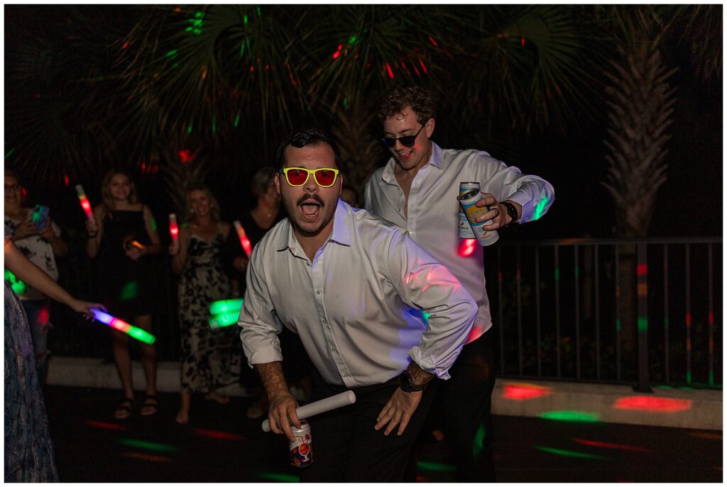 Groom and best man being silly on dance floor 