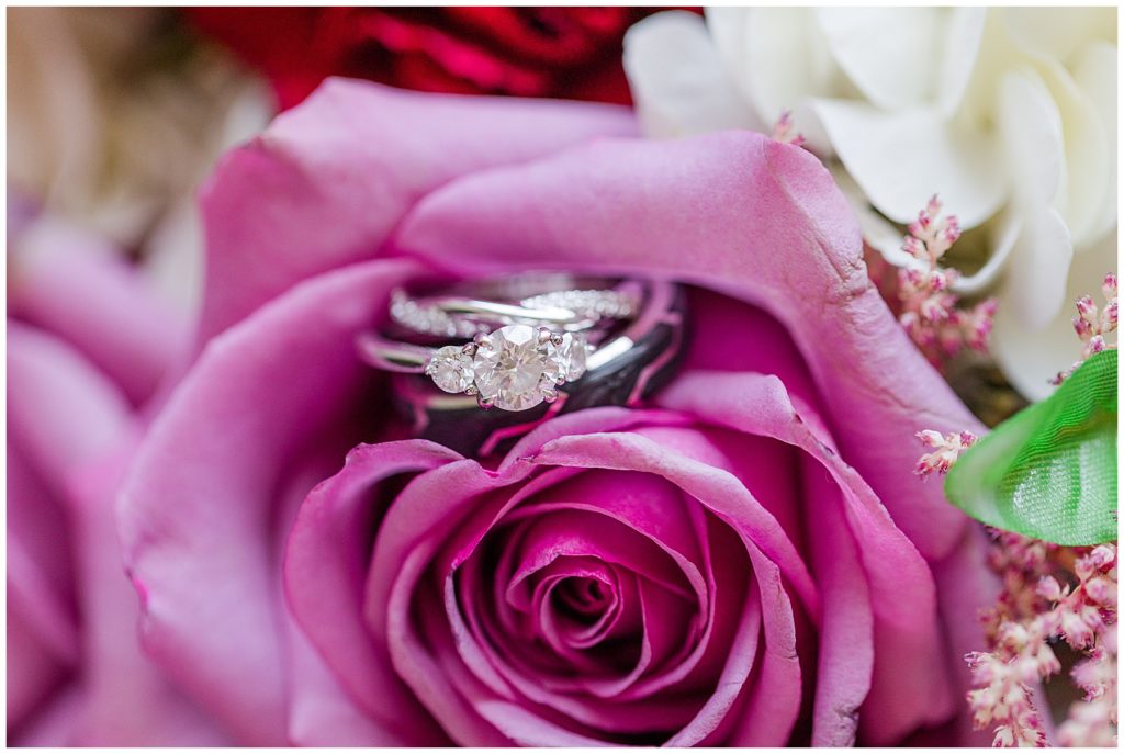 A set of three wedding rings nestled in a pink rose | Taylor'd Southern Events