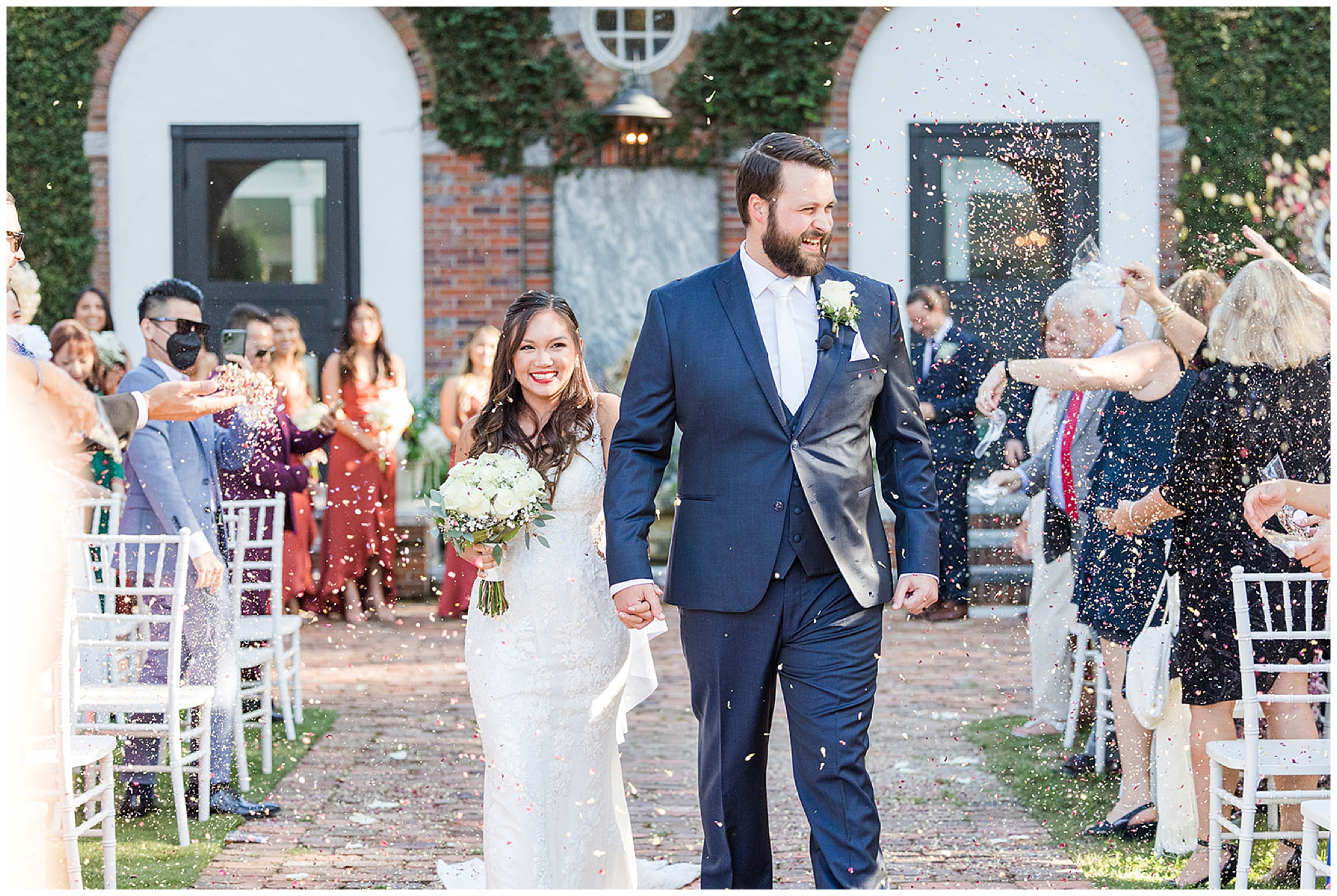 Newlyweds walk down the brick path aisle of their wedding ceremony while guests celebrate by throwing confetti over them at south eden plantation